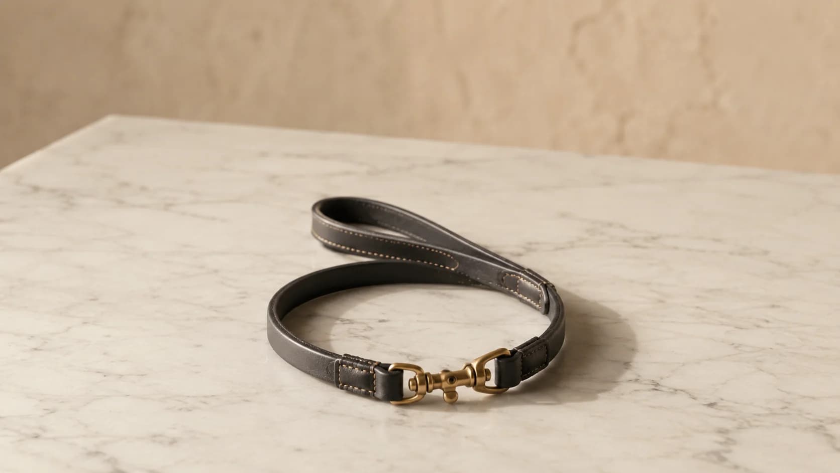 Correa corta de cuero carbón con asa doblada y mosquetón de gatillo de latón macizo.
