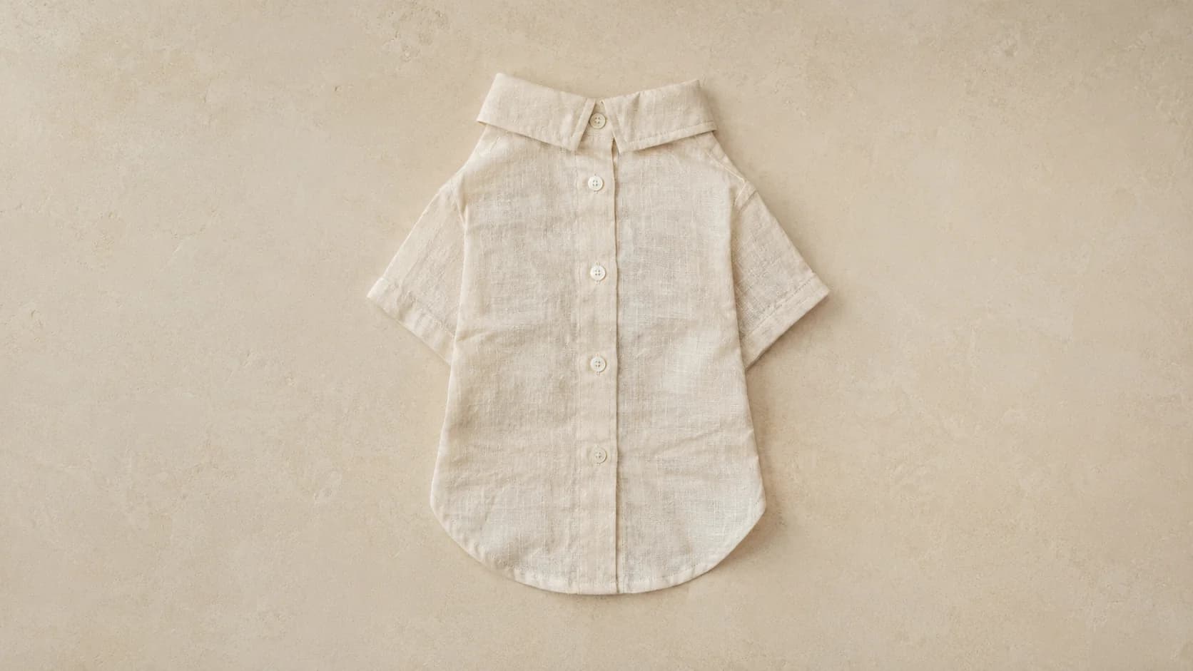 Camisa de lino lavado alabastro extendida, con cuello y botones de nácar.