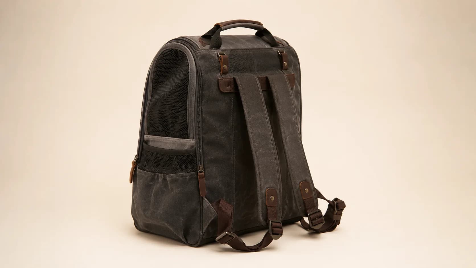 Bolso mochila de lona encerada carbón visto por detrás, con tirantes acolchados.