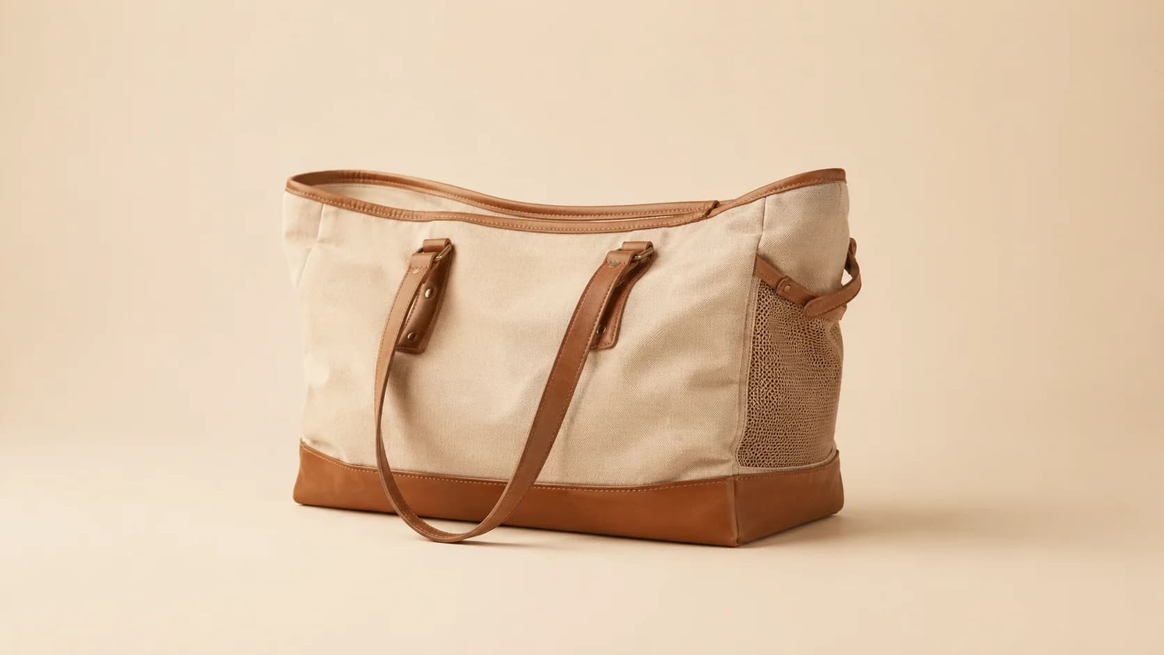 Bolso de lona de algodón arena con base de cuero y asas de cuero.
